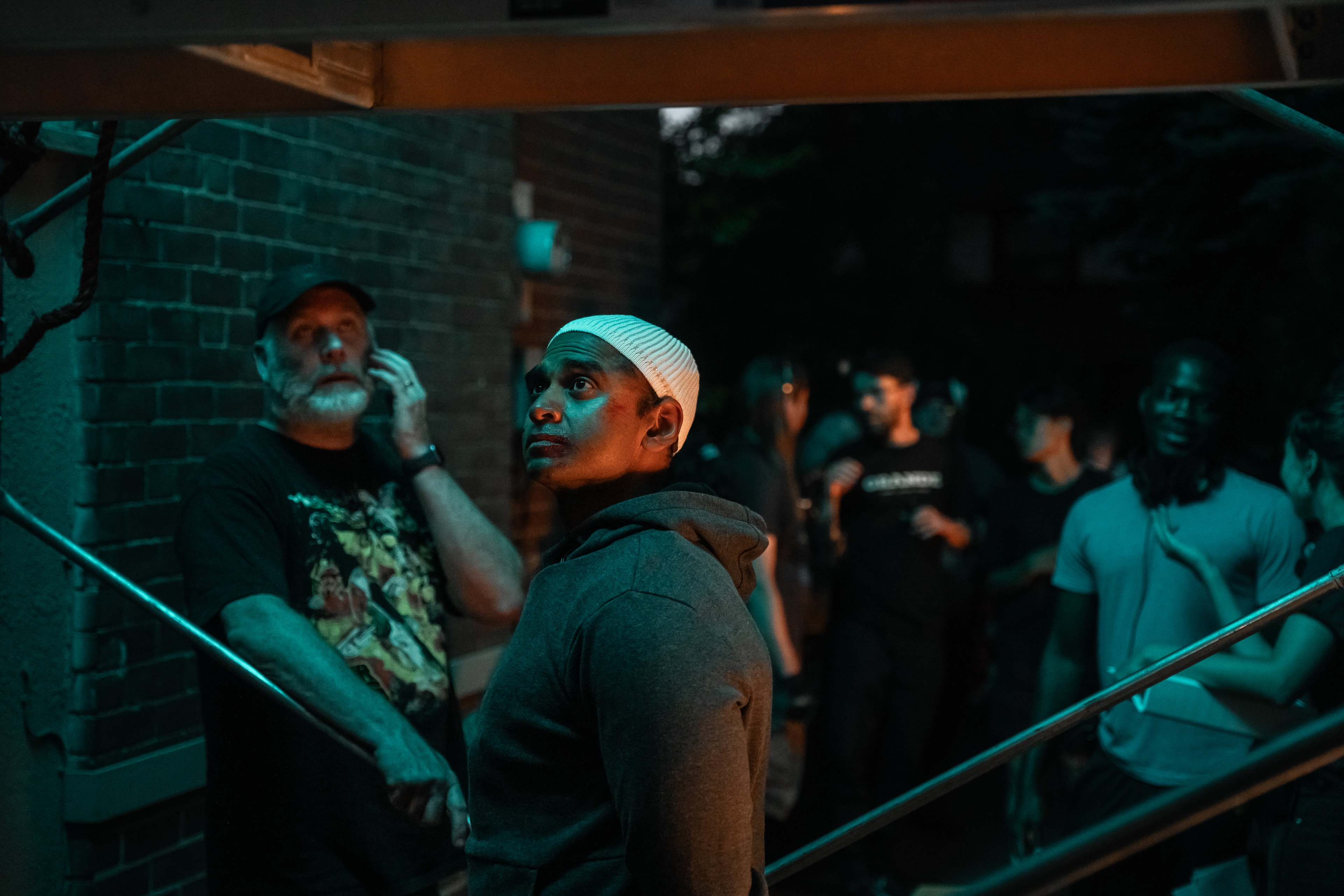 Behind the scenes — crew on stairwell with teal lighting