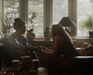 Two people in conversation by a sunlit window